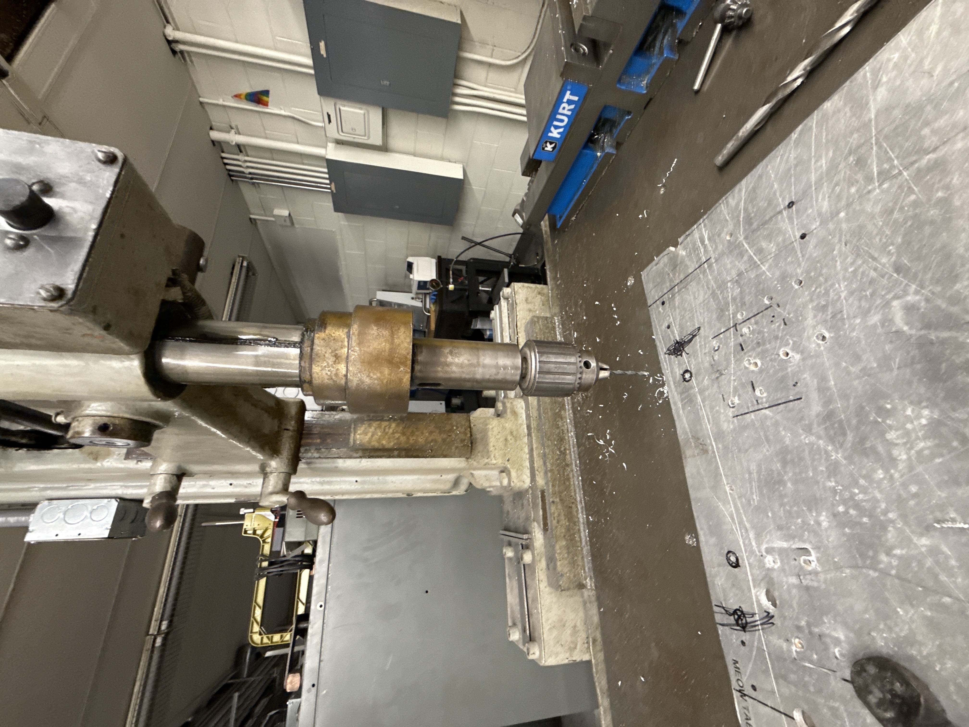 Drilling pilot holes into the aluminum base plate for 1/2 in. bolt holes